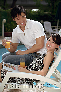 Asia Images Group - Young couple laughing at the pool