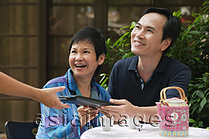 Asia Images Group - Mature couple being handed menu in restaurant