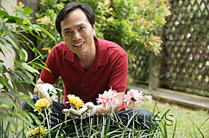 Asia Images Group - Man gardening and smiling at camera