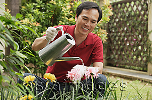 Asia Images Group - Man watering plants in the garden