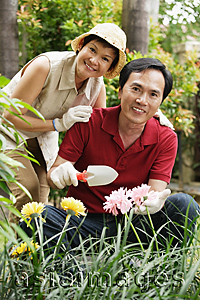 Asia Images Group - Mature couple smiling at camera while gardening