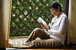 Asia Images Group - Woman reading book in the garden
