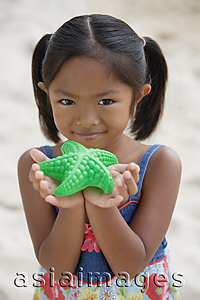 Asia Images Group - Girl with starfish smiling at camera