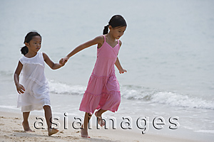 Asia Images Group - Sisters running while holding hands at the beach