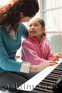 Asia Images Group - Piano teacher and girl playing piano