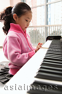 Asia Images Group - Young girl playing piano