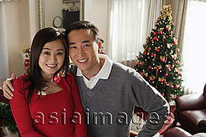 Asia Images Group - Young couple at Christmas time smiling at camera
