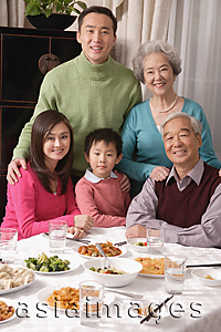 Asia Images Group - Family at dinner table with traditional food