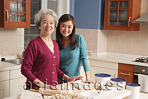 Asia Images Group - Mother and daughter making dumplings in the kitchen