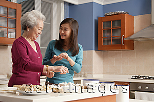 Asia Images Group - Mother and daughter making dumplings in the kitchen