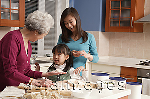 Asia Images Group - Grandmother, daughter and granddaughter making dumplings in the kitchen