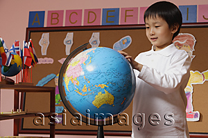 Asia Images Group - Schoolboy looking at globe