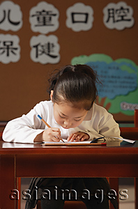 Asia Images Group - Schoolgirl writing at the desk
