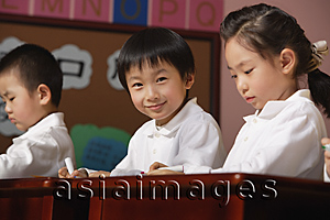 Asia Images Group - Students in class, schoolboy smiling at camera