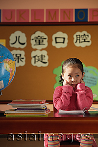 Asia Images Group - Girl sitting in class, looking away from camera