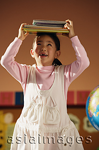 Asia Images Group - Girl balancing school books