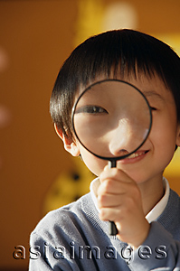 Asia Images Group - Schoolboy with magnifying glass