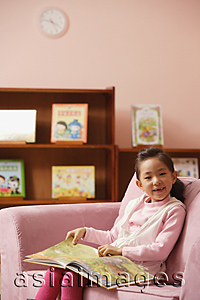 Asia Images Group - Young girl with book smiling at camera