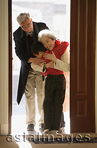 Asia Images Group - Boy greeting grandparents at door