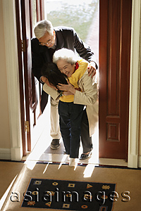 Asia Images Group - Girl greeting grandparents at door