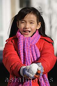 Asia Images Group - Young girl with snowball looking at camera
