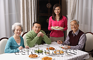 Asia Images Group - Family at dinner table having traditional food