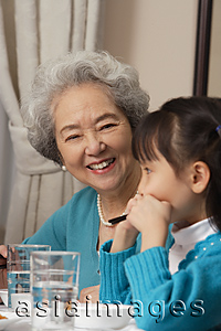 Asia Images Group - Grandmother and grandchild at dinner table