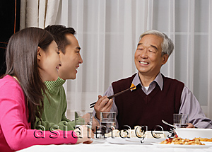 Asia Images Group - Young couple and elderly father at dinner table