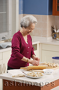 Asia Images Group - Elderly woman baking in the kitchen
