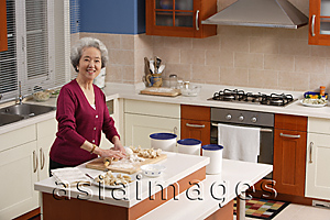 Asia Images Group - Elderly woman baking in the kitchen
