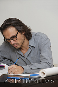 Asia Images Group - Man sitting at desk drawing