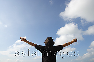 Asia Images Group - Man looking at the sky, arms outstretched