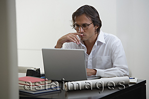 Asia Images Group - Businessman using laptop at the desk
