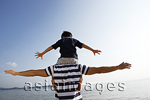 Asia Images Group - Father piggybacking son at the beach