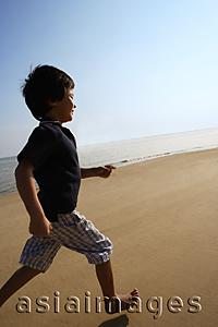 Asia Images Group - Young boy running on the beach