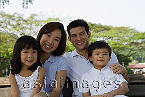 Asia Images Group - Young family sitting on park bench