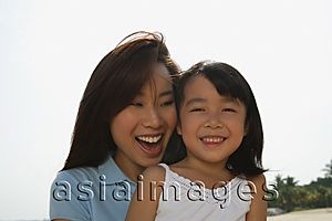 Asia Images Group - Mother and daughter smiling at the beach