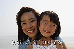 Asia Images Group - Mother and daughter at the beach, smiling at camera