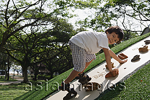 Asia Images Group - Young boy playing on rock-climbing wall