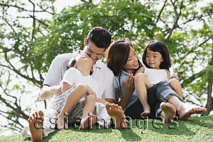 Asia Images Group - Young family sitting on ground at the park