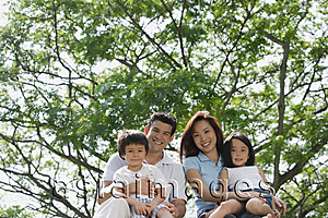 Asia Images Group - Young family at the park, looking at camera