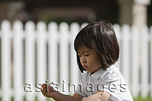 Asia Images Group - Young girl playing in the garden