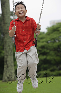 AsiaPix - Boy on playground swing, smiling