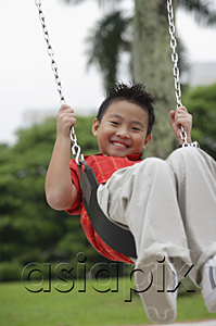 AsiaPix - Boy swinging, smiling at camera