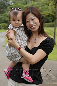 AsiaPix - Mother carrying young daughter, smiling at camera