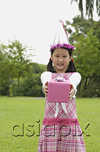 AsiaPix - Girl with party hat holding pink gift box towards camera