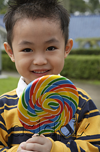 AsiaPix - Boy holding colourful lollipop