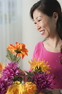 AsiaPix - Mature woman looking at flowers, smiling
