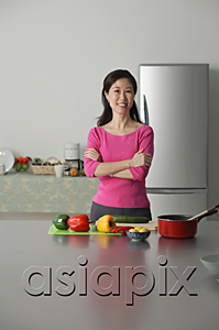 AsiaPix - Mature woman in kitchen, arms crossed, looking at camera