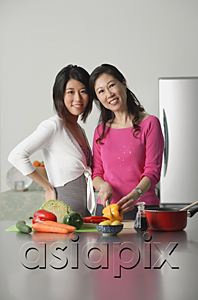 AsiaPix - Mother and adult daughter in kitchen, looking at camera